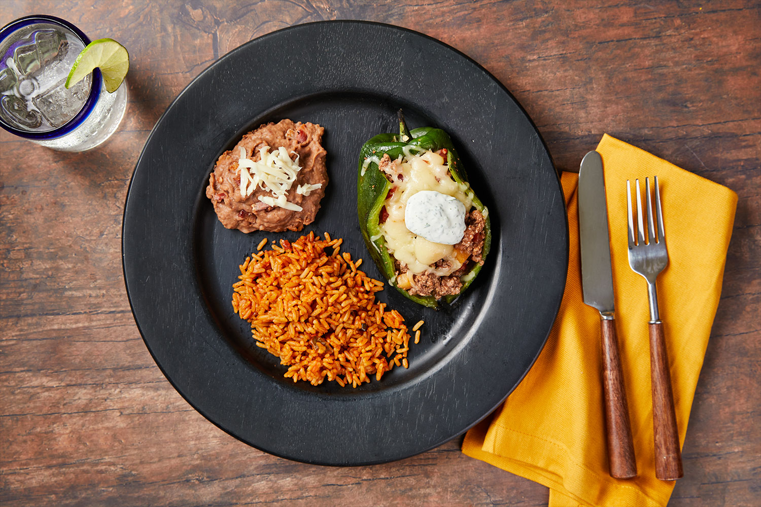 Beef Picadillo Stuffed Peppers with Mexican Rice and Refried Beans